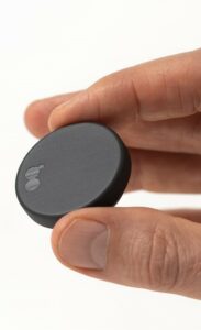 Närbild av en hand som håller i en rund, svart sensor