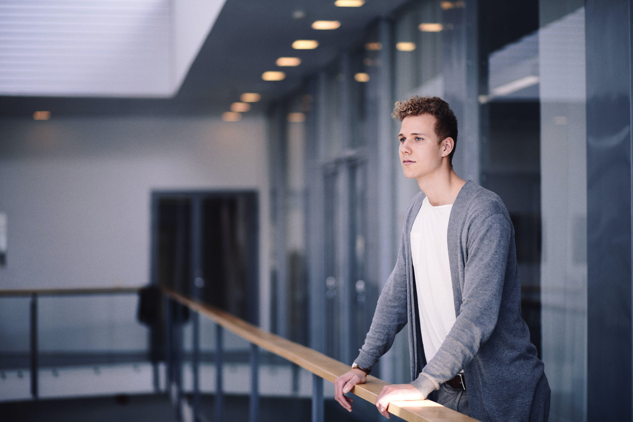 Människa lutad mot räcke, tittar framåt.