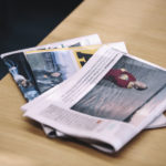 Tre dagstidningar på ett bord.