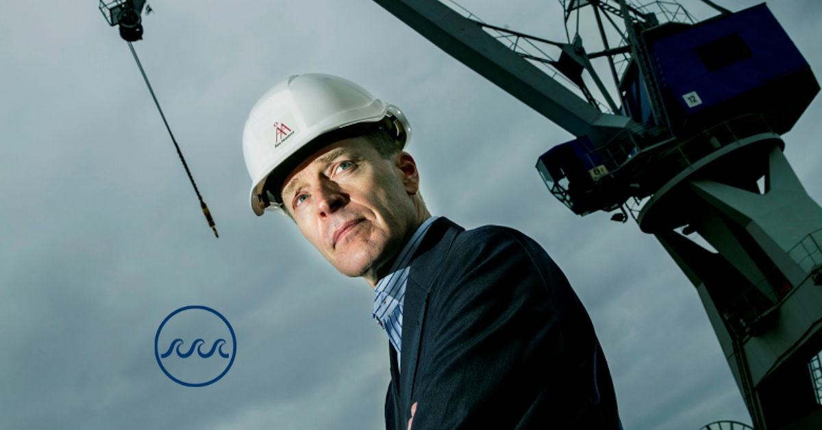 Kim Wikström står framför en lyftkran. Bakgrunden är hotfullt grå. I det nedre vänstra hörnet syns en logo bestående av tre vågor inne i en cirkel.