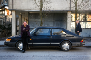 Professor Jyri-Pekka Mikkola står med armarna i kors och lutar sig mot sin pappas gamla Saab.